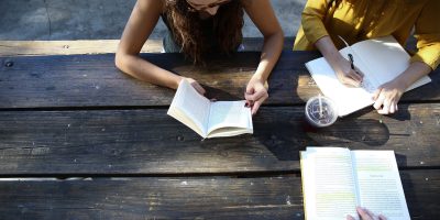 woman reading book while sitting on chair