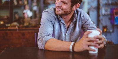 man holding cup on table